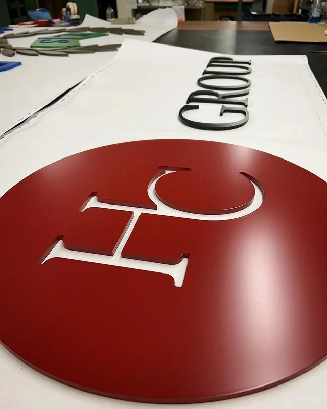 Project 116: Round red logo panel with dimensional white acrylic lettering.