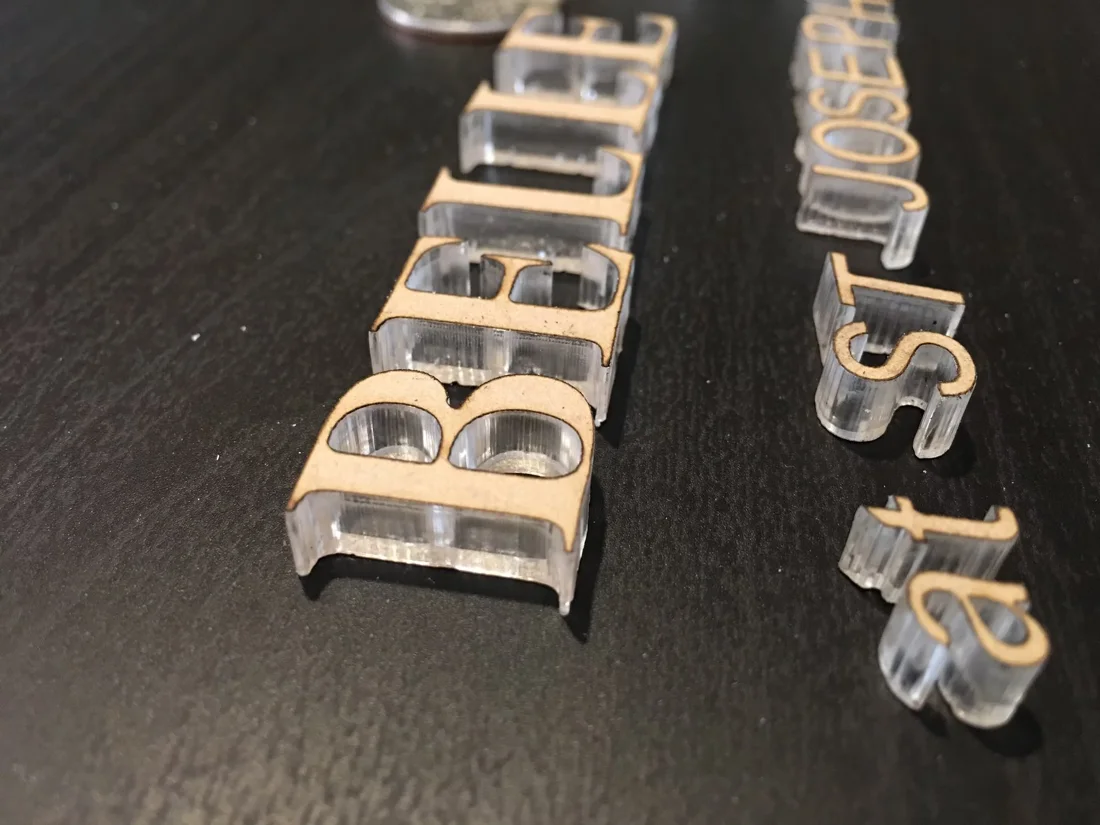 Clear acrylic dimensional letter set prepared for finishing or installation.