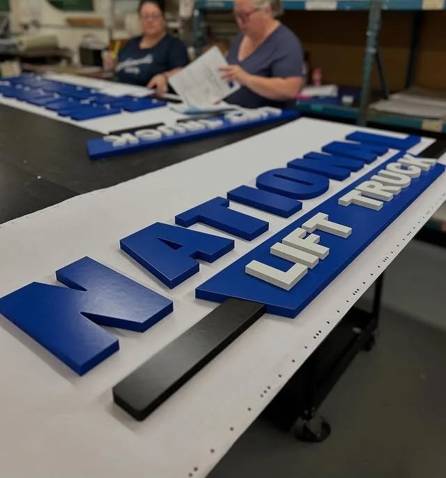 Blue and white corporate dimensional letters in the sign shop