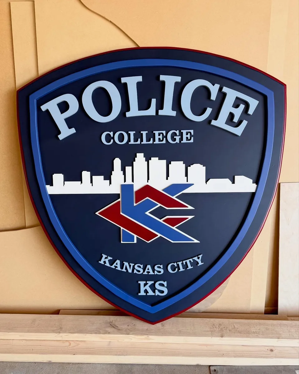 Police College — Kansas City, KS — Shield-shaped dimensional sign with layered lettering and emblem detail.