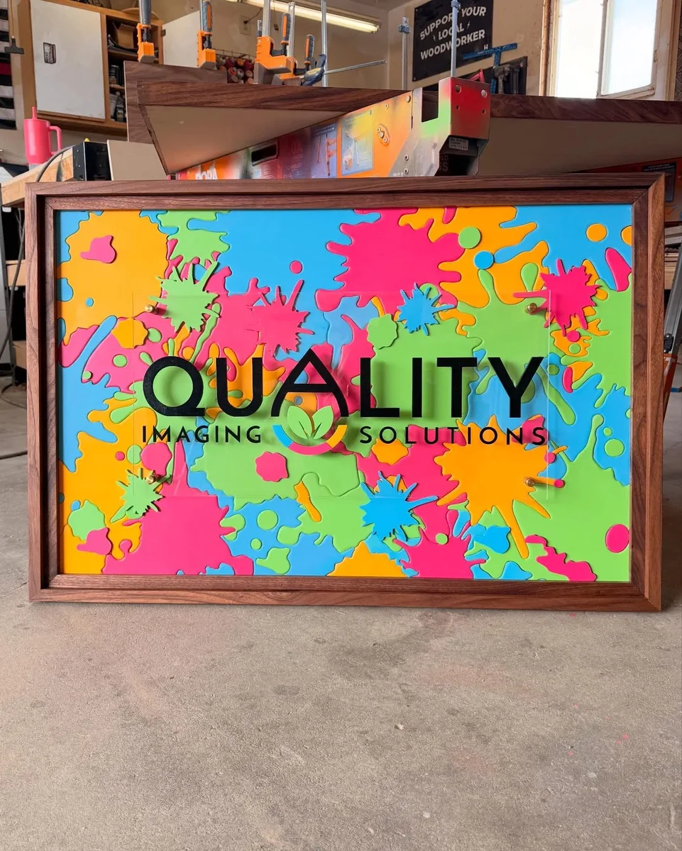 Quality Imaging Solutions — Bright dimensional business sign with layered branding and a framed panel.