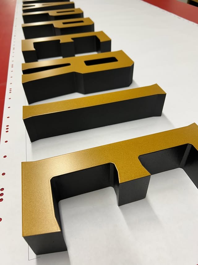 Black and gold dimensional letter set showing layered side depth