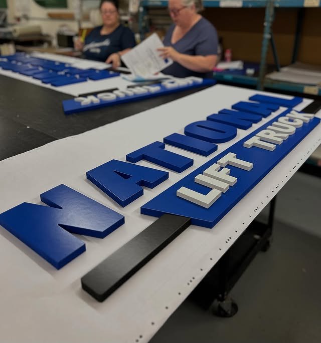 Blue and white corporate dimensional letters in the sign shop