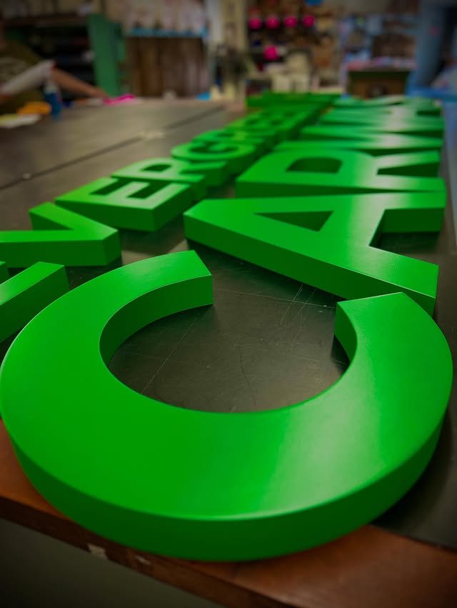 Bright green dimensional letters showing routed edges and depth