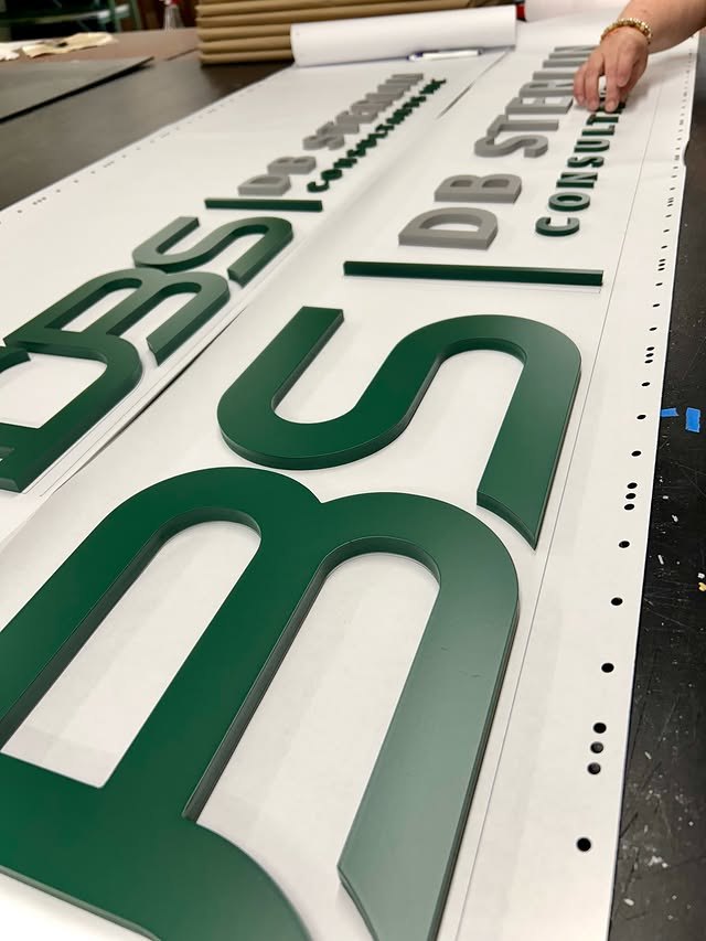 Green BSI dimensional logo and letter set on a production table