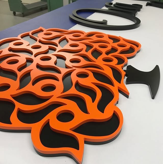 Orange and black layered tree logo fabricated from acrylic
