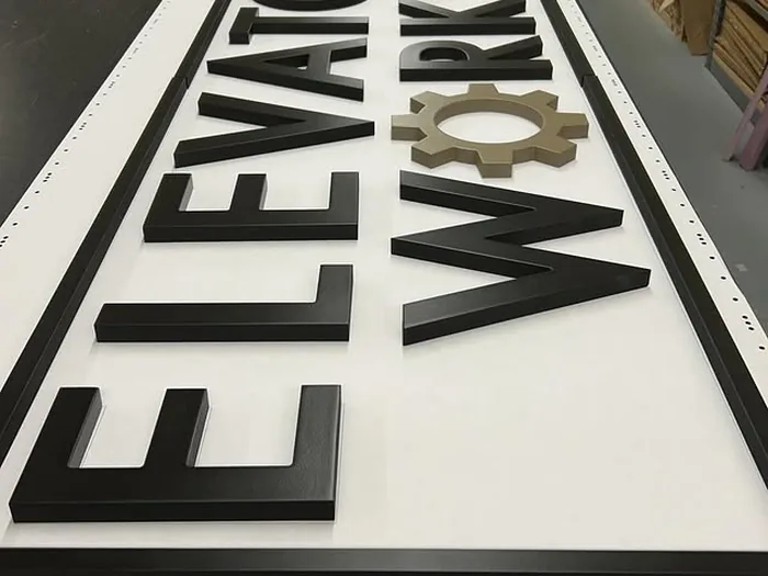 Black dimensional letters positioned on a white production panel