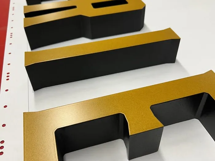 Black and gold dimensional letter set showing layered side depth