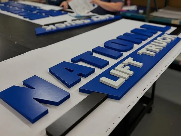 Blue and white corporate dimensional letters in the sign shop