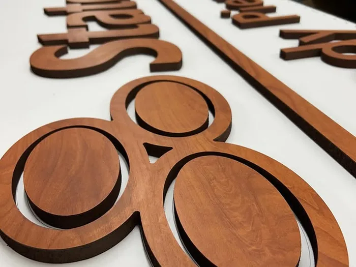 Brown woodgrain dimensional letters and circular logo pieces