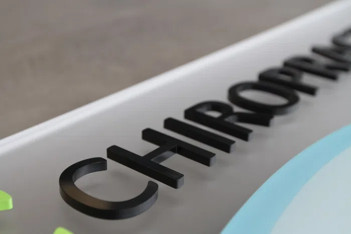 Black chiropractic dimensional letters on a white panel