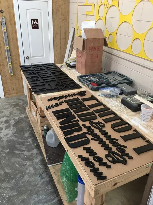 CNC-cut dimensional letters and sign components on a worktable