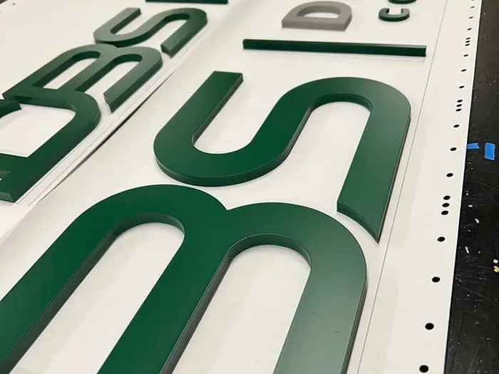 Green BSI dimensional logo and letter set on a production table