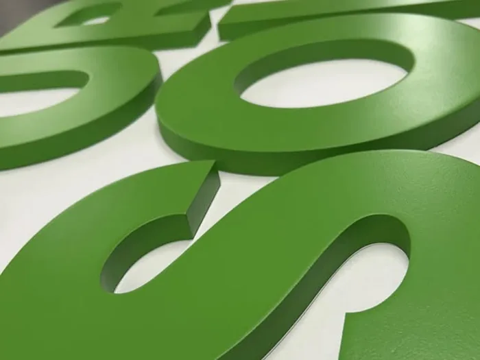 Green dimensional logo letters in a close production view