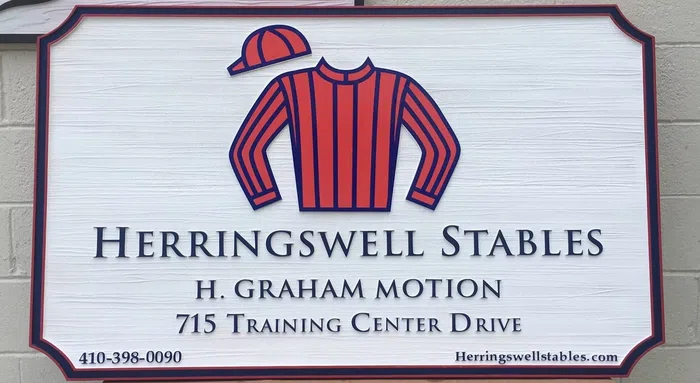 Herringswell Stables farm sign with riding jacket graphic