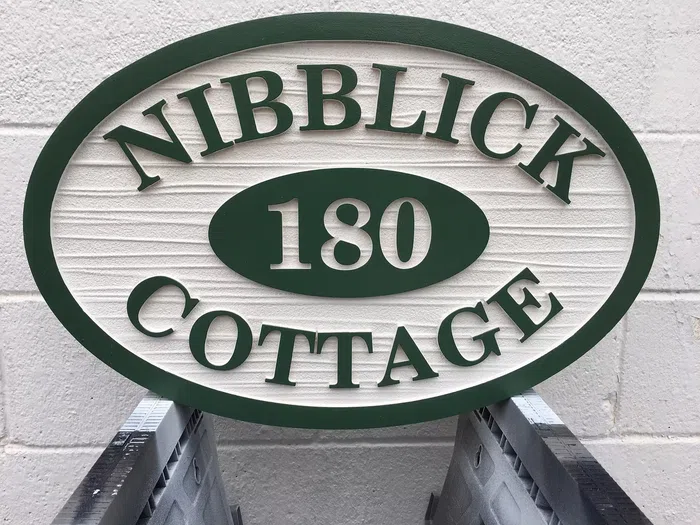 Green oval Nibblick Cottage sign