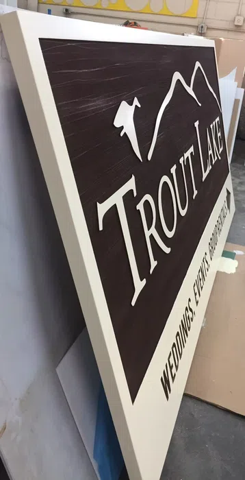 Dark carved-style Trout Lake property sign