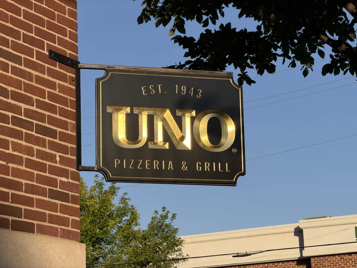 Installed Unto Pizzeria and Grill hanging sign with raised gold letters