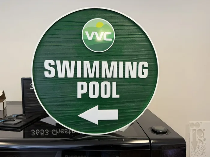 Alternate view of round green VVC Swimming Pool directional sign with left arrow